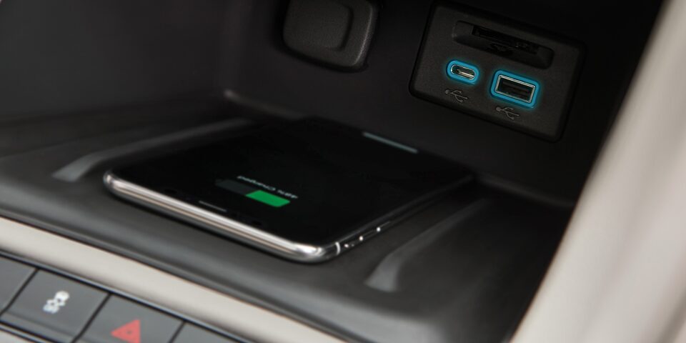Moderno cargador inalámbrico para smartphone en el interior de GMC Acadia 2023