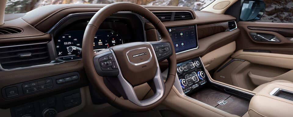 Interior de GMC Yukon 2023, camioneta lujosa con piel premium perforada y bordados